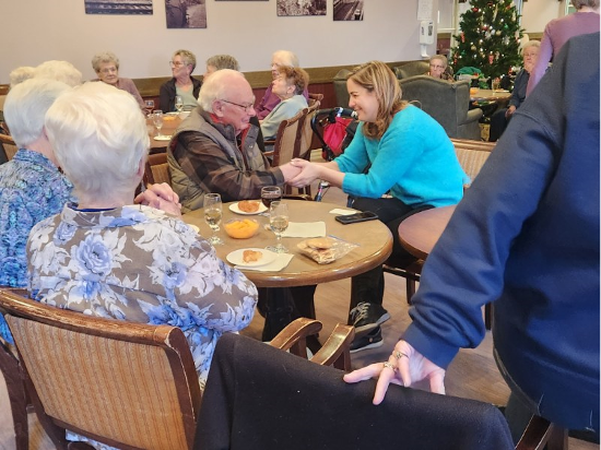 Seniors at a table talking with an MLA
