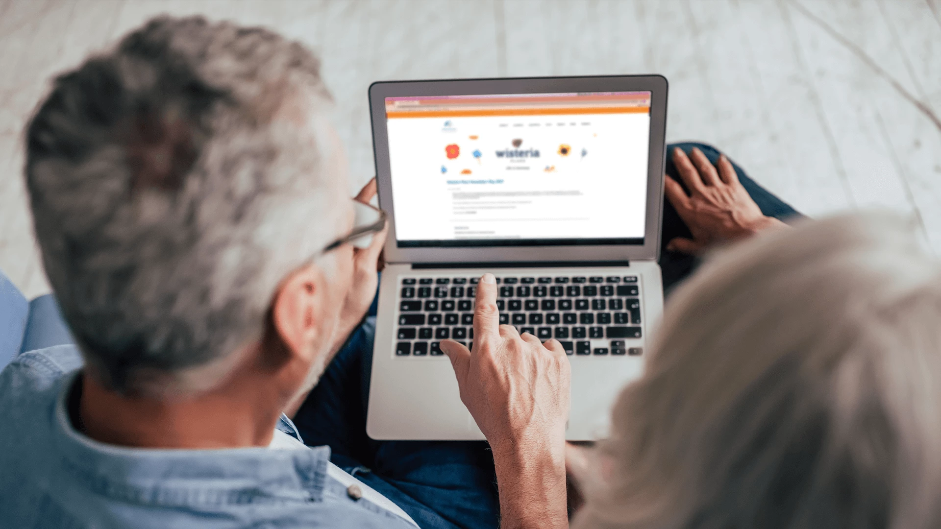 A senior woman and man looking at a laptop screen