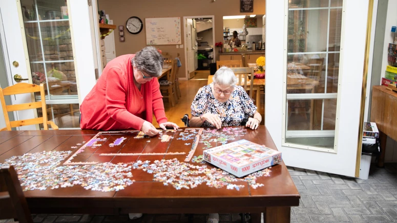 Two seniors building a puzzle together